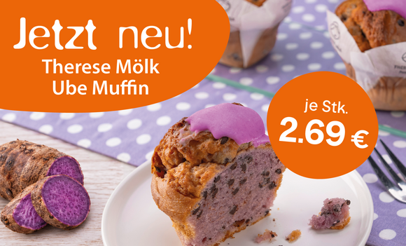 Ube Muffin mit lila Topping auf einem Teller, daneben geschnittene lila Süßkartoffel. Im Hintergrund weitere Muffins und ein lila gepunktetes Tuch. Preisangabe: 2,69 € pro Stück.